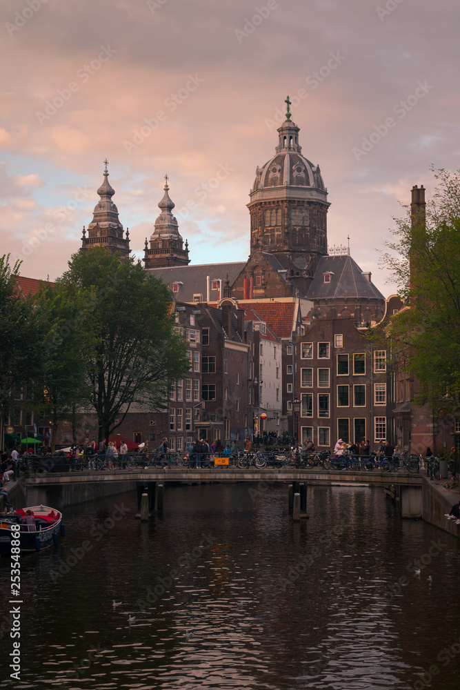 Fototapeta premium Church of Saint Nicholas dominating the main canal from Red Lights District at the center of Amsterdam, Holland, The Netherlands.
