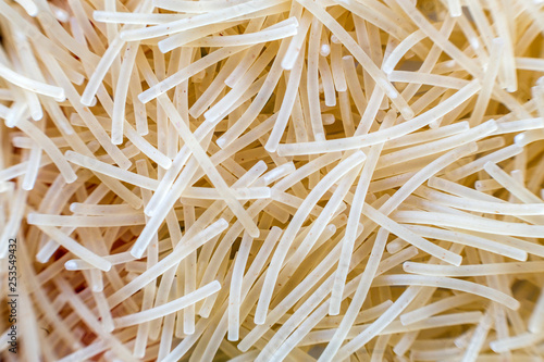 Fototapeta Naklejka Na Ścianę i Meble -  Close-up of raw dry uncooked pasta, abstract background. Italian traditional cuisine popular ingredient, nutrition, healthy tasty diet concept.