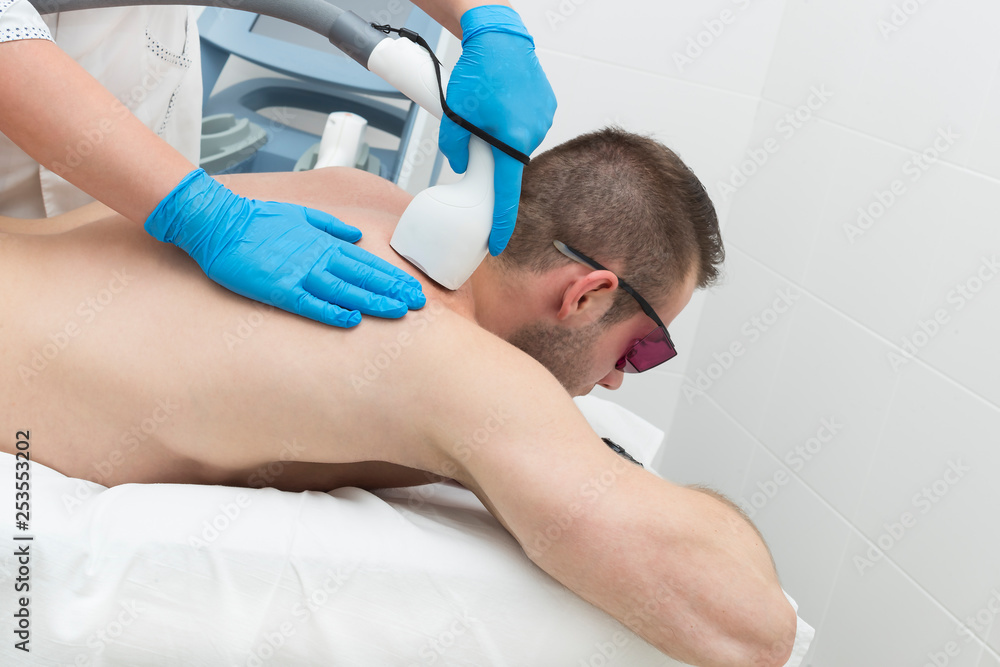 Man on the procedure of laser hair removal in the beauty salon Man on the procedure of laser hair removal in the beauty salon
