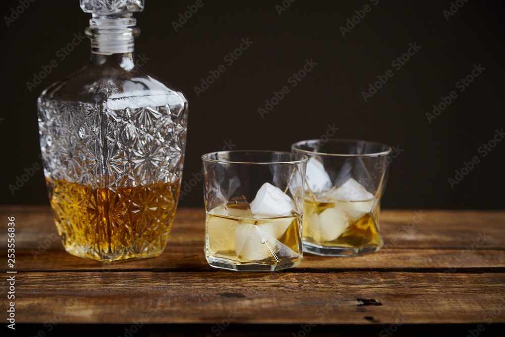 Whiskey with ice in glasses, rustic wood background, copy space Whiskey with ice in glasses, rustic wood background, copy space