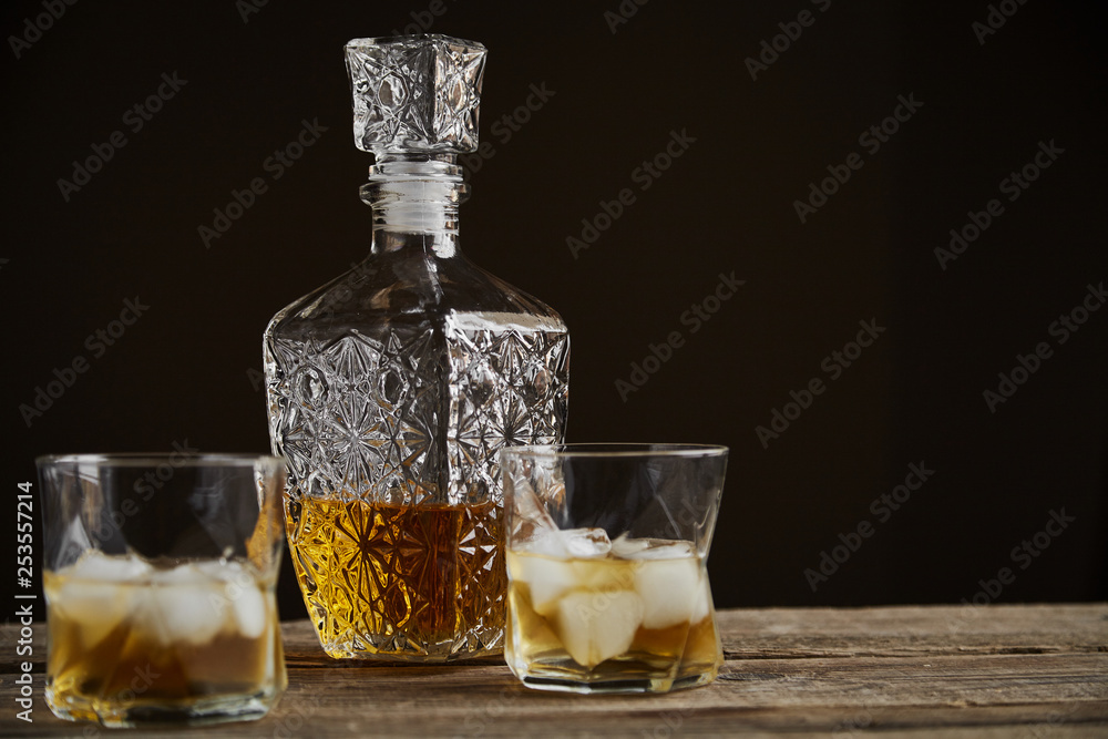 Whiskey with ice in glasses, rustic wood background, copy space Whiskey with ice in glasses, rustic wood background, copy space