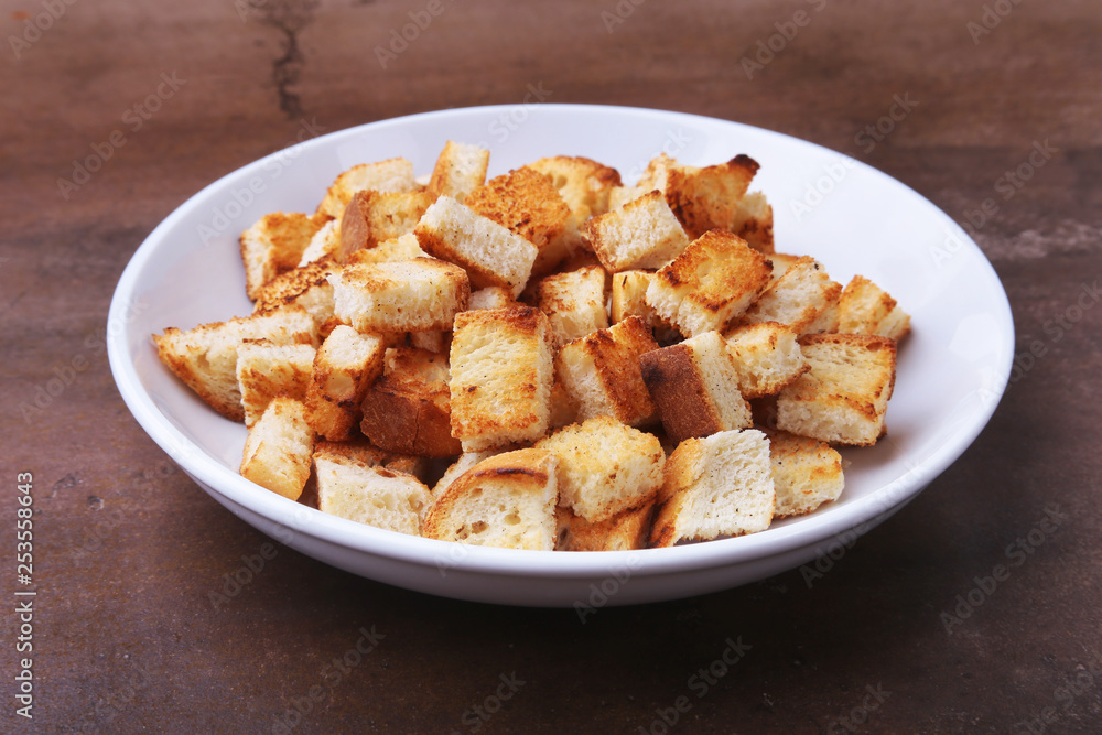 Delicious crispy croutons, crumbs of bread in white plate. ready for cooking. Delicious crispy croutons, crumbs of bread in white plate. ready for cooking.