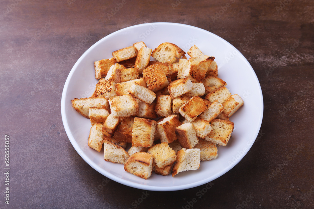 Delicious crispy croutons, crumbs of bread in white plate. ready for cooking. Delicious crispy croutons, crumbs of bread in white plate. ready for cooking.