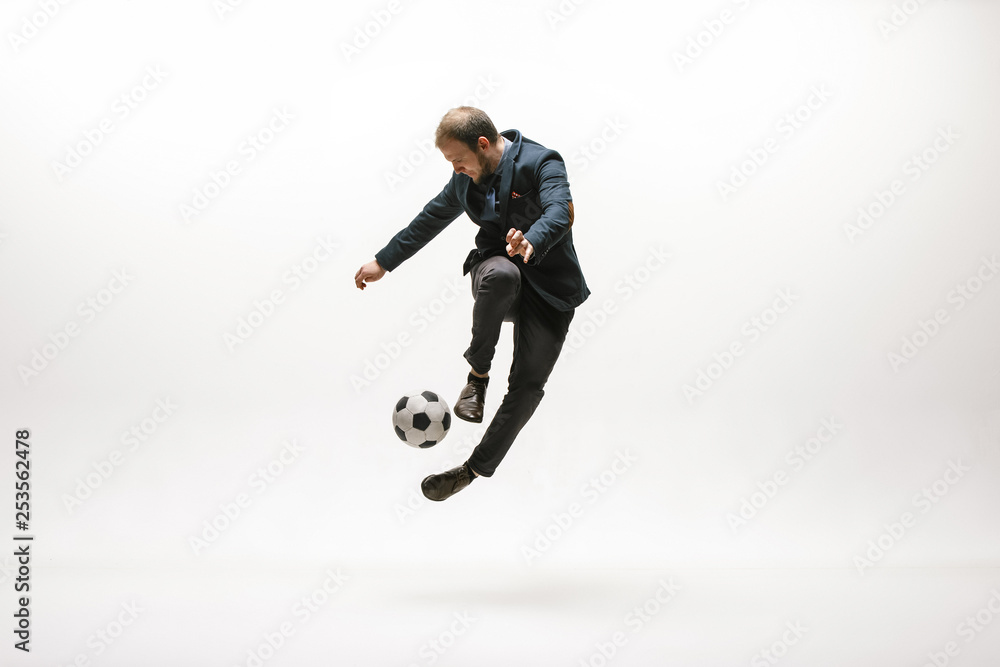 Businessman with football ball in office. Soccer freestyle. Concept of balance and agility in business. Manager perfoming tricks isolated on white studio background.