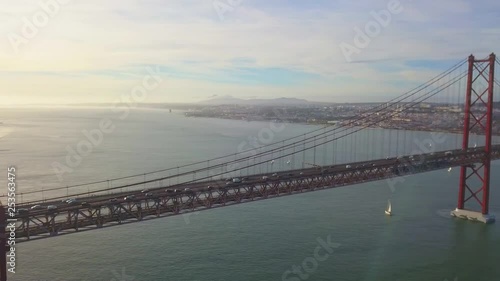 Traffic on 25 april bridge Lisbon with a boat and the city in the background photo