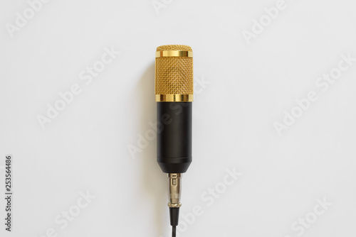 The black yellow microphone with the wire on a white background. Minimalism. Copy space for text