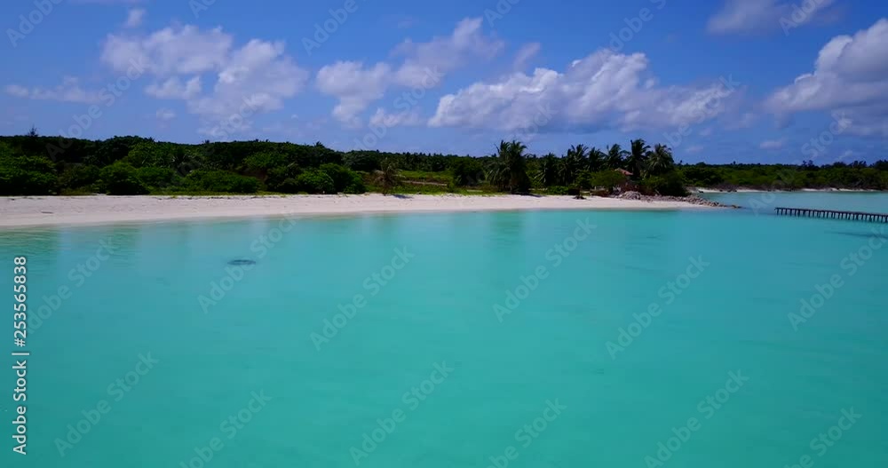 Secluded lagoon with old wooden pier and white sandy beach, no people, pan left Secluded lagoon with old wooden pier and white sandy beach, no people, pan left