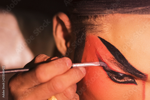 Chinese opera actress is painting her face backstage. photo