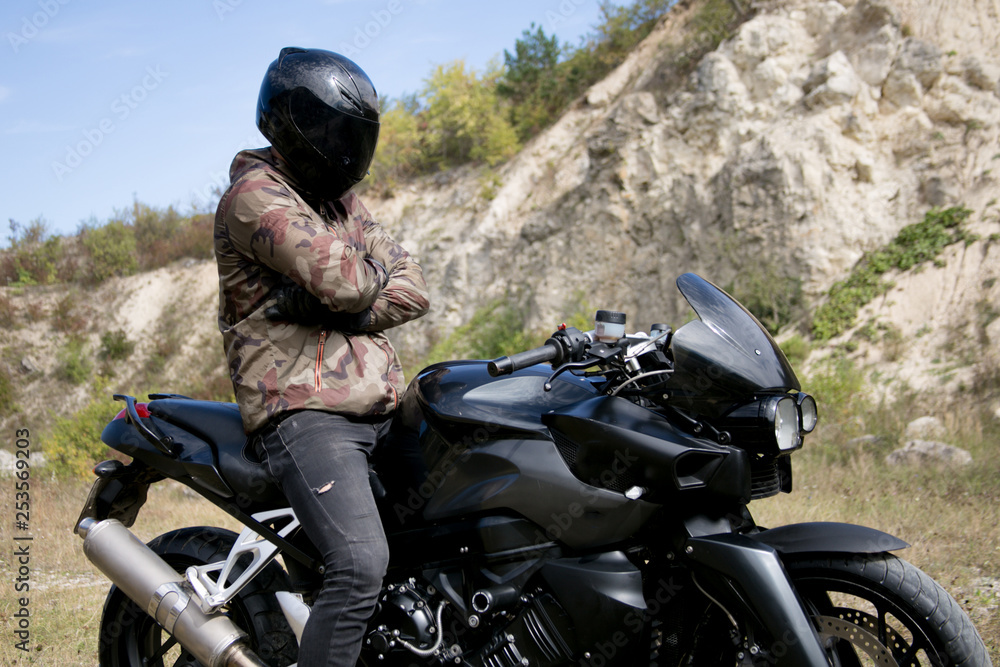 Journey to a motorcycle through a career. The motorcyclist wearing a helmet on a motorcycle Journey to a motorcycle through a career. The motorcyclist wearing a helmet on a motorcycle