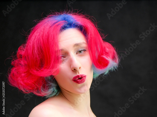 High fashion model woman with multi-colored hair posing in studio, portrait of beautiful sexy girl with a fashionable makeup and manicure.