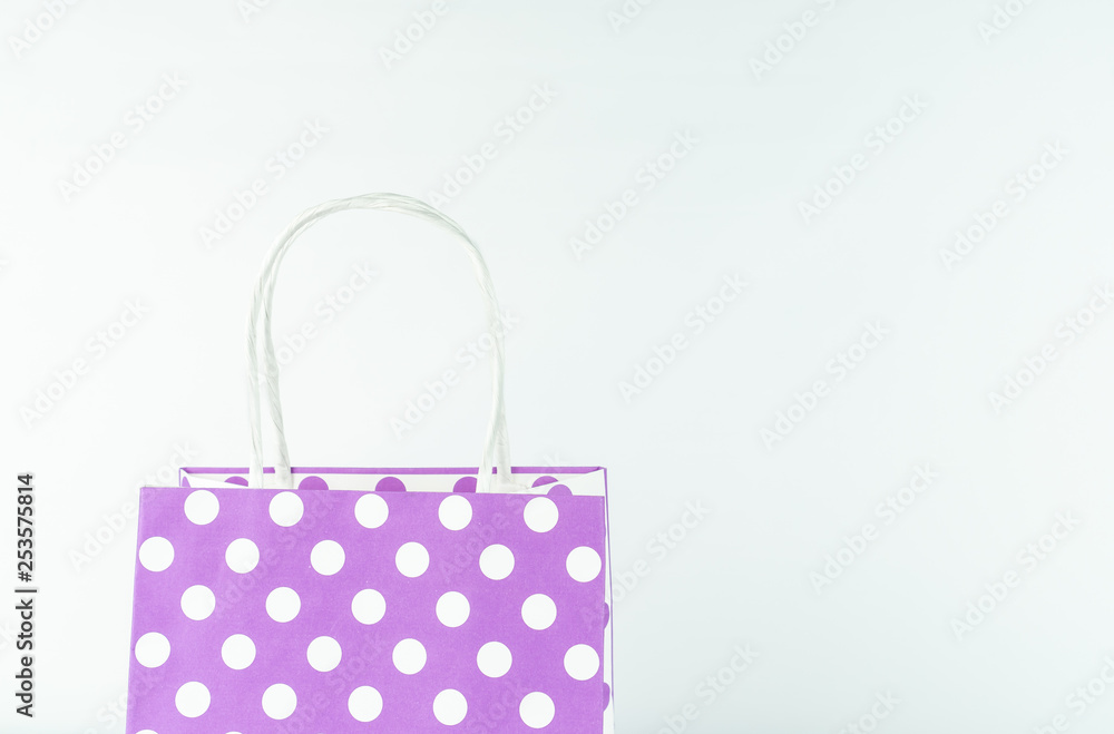 Purple gift bag with white dots, white background and copy space Purple gift bag with white dots, white background and copy space