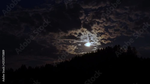 Time lapse, shot of the moon moving between clouds, in a norwegian night, in Birkeland, South Norway photo