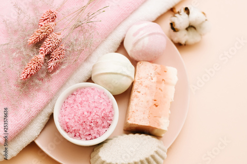 Bath pampering set. Beauty care and relaxation leisure. Assorted cosmetic products on coral pink background.