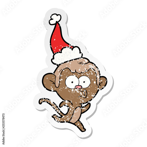 distressed sticker cartoon of a surprised monkey wearing santa hat
