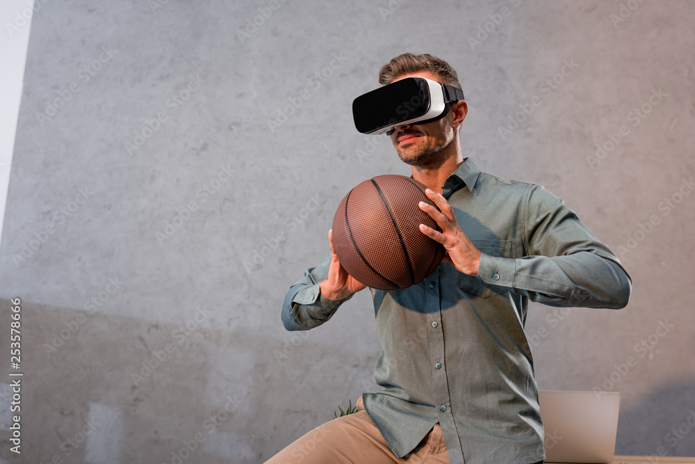 businessman in virtual reality headset holding basketball in office businessman in virtual reality headset holding basketball in office