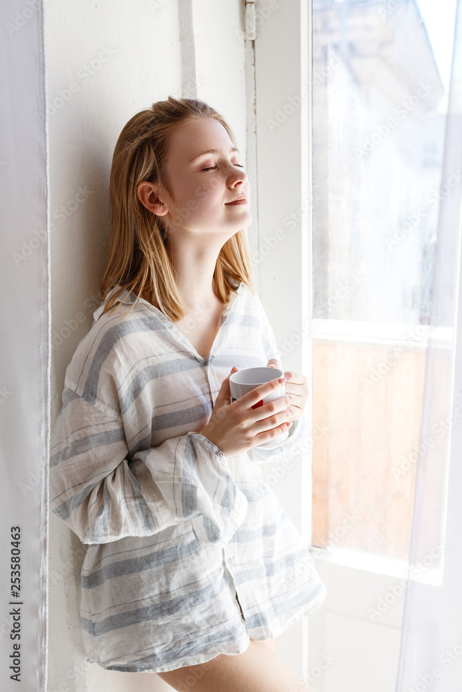 Pretty young woman in modern apartment stretching after wake up Pretty young woman in modern apartment stretching after wake up