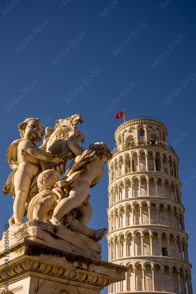 The leaning tower of pisa at Piazza del Miracoli Duomo square with medieval statue in Tuscany, Italy