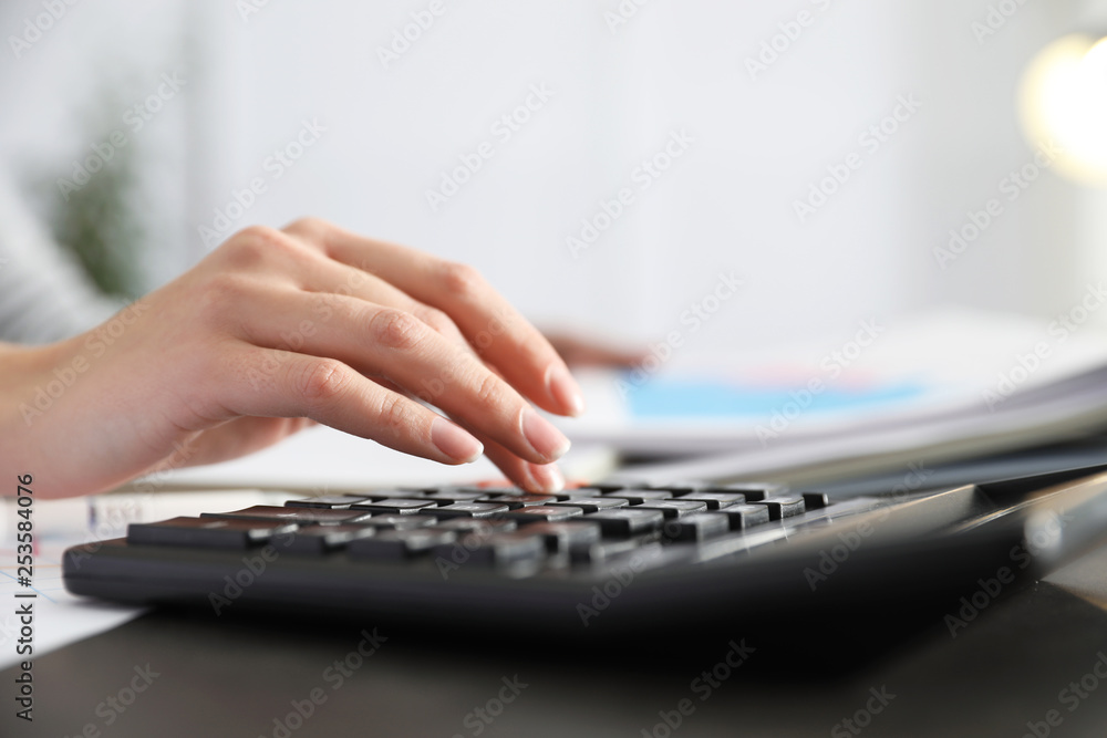 Office employee working with calculator and documents at table, closeup Office employee working with calculator and documents at table, closeup