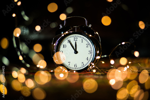 alarm clock on the eve of the holiday shrouded in garland