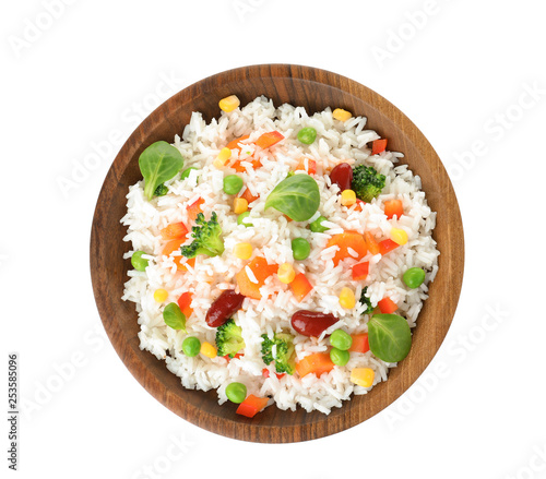 Bowl with tasty rice and vegetables on white background, top view photo