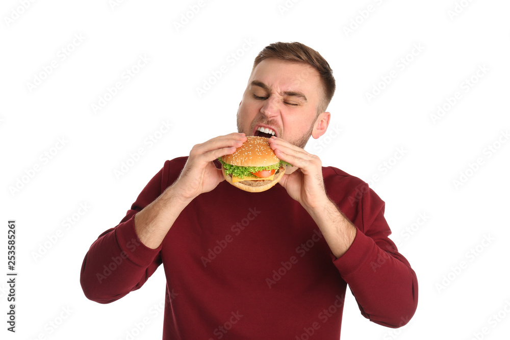Young man eating tasty burger on white background Young man eating tasty burger on white background