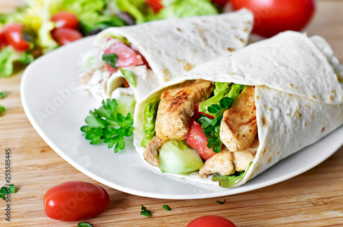 Delicious fresh chicken wrap, closeup shot. Tasty tortilla with salad and turkey meat,healthy eating scene. 