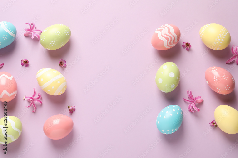 Flat lay composition with painted Easter eggs on color background, space for text