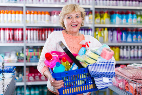Happy female holding basket in shop