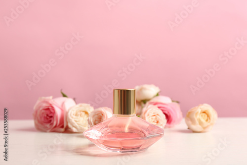 Fotografía Bottle of perfume with beautiful roses on table