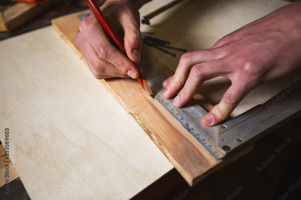 Carpenter marks the floor board Carpenter marks the floor board