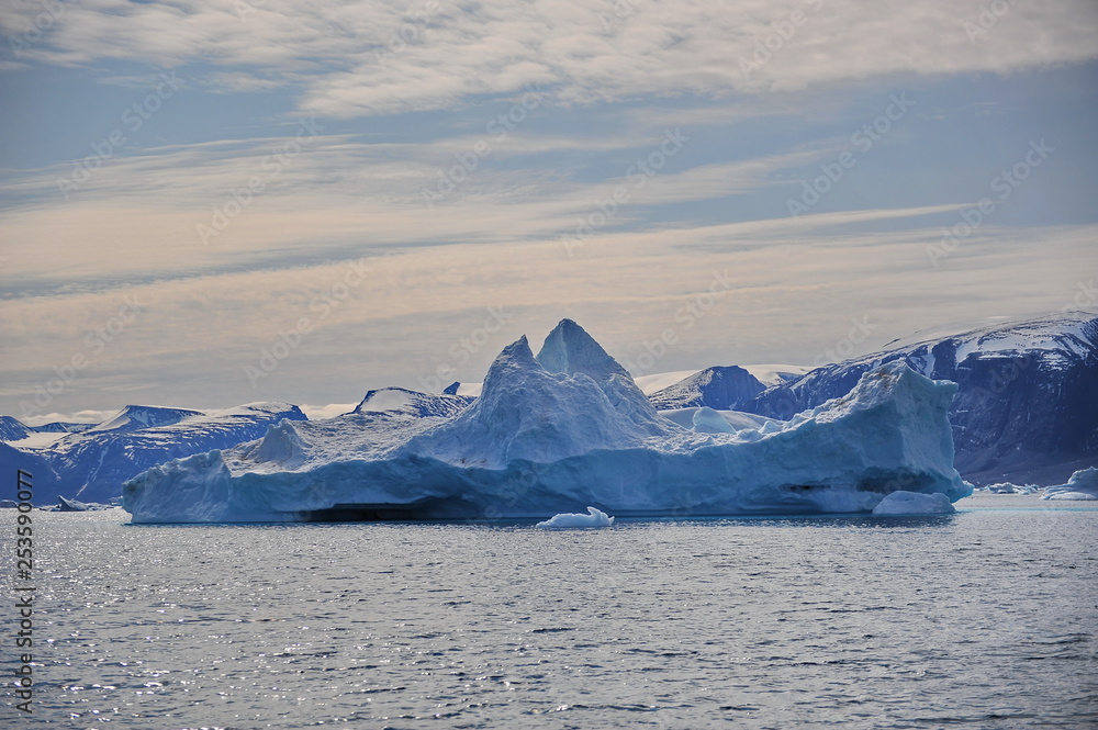 Iceberg, mountains, water, sky.