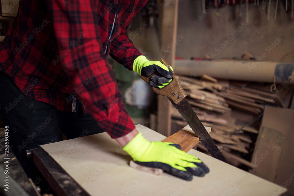  Worker using a hand saw 