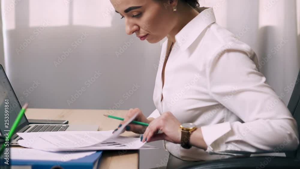 Female office worker viewing documents in workplace Female office worker viewing documents in workplace
