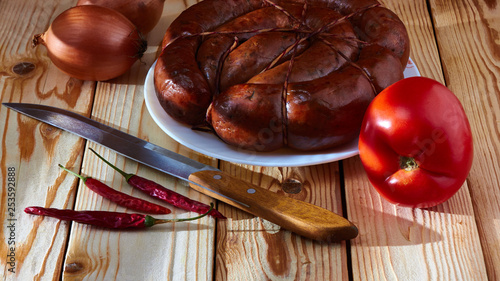 Fotografija Preparation of a festive table, on a table of smoked sausage, a tomato, onions and acute red pepper to improve apetit