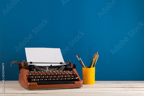 writer's workplace - red typewriter and stationery on blue blackboard background