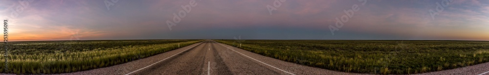 panorama of a straight road through the outback of Australia, after a beautiful sunset, Nothern territory