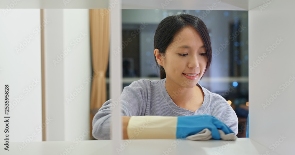 Woman clean the cabinet at home Woman clean the cabinet at home