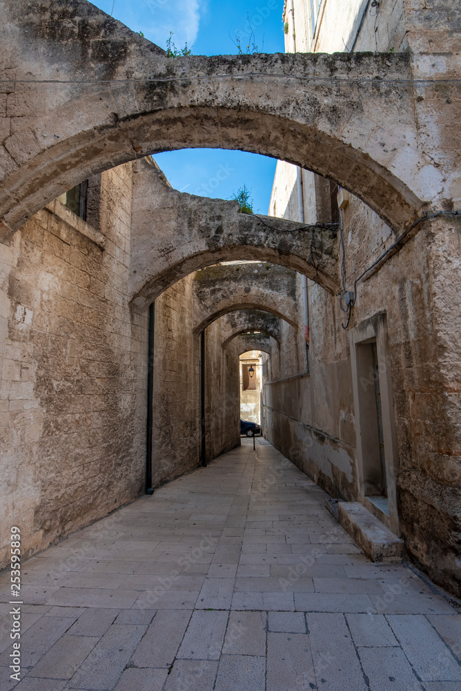Street and alley with a arches view of colorful houses in the old town. A region of Apulia. Monopoli, Puglia, Italy 