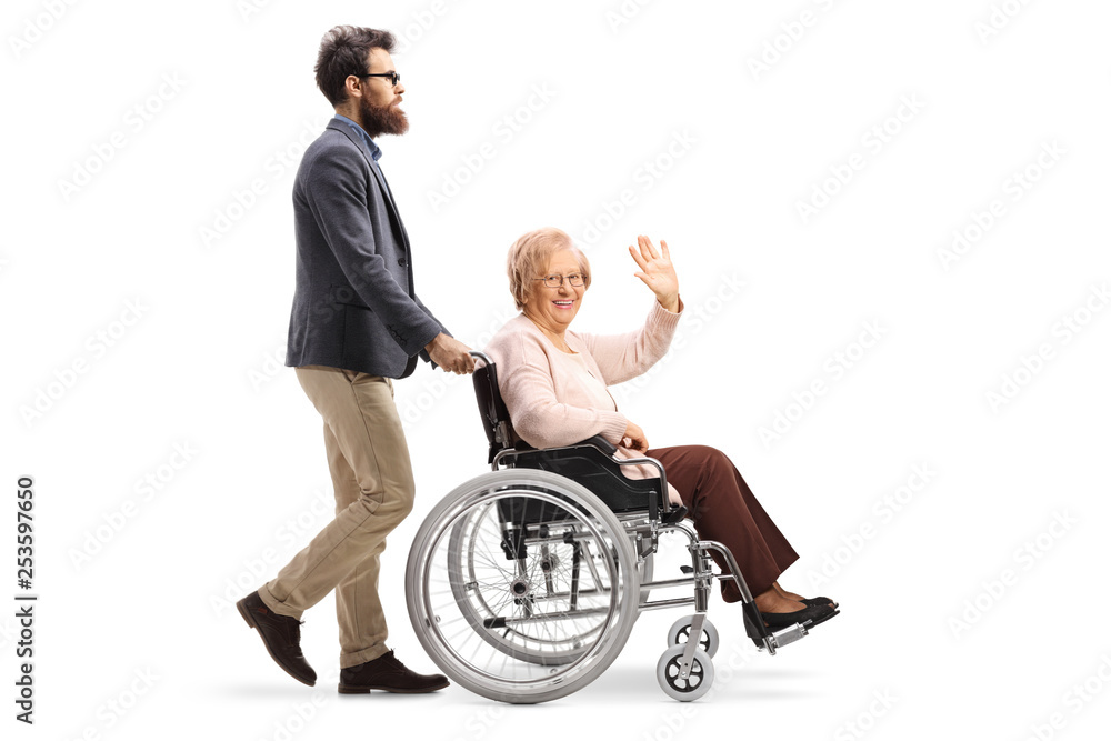 Man pushing a senior woman in a wheelchair waving Man pushing a senior woman in a wheelchair waving