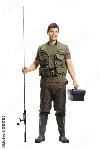 Young fisherman posing with a fishing rod and a case