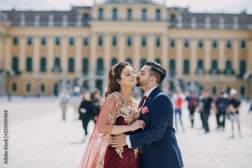 Photography Beautiful woman in a long red dress walks around the city with her husband in a