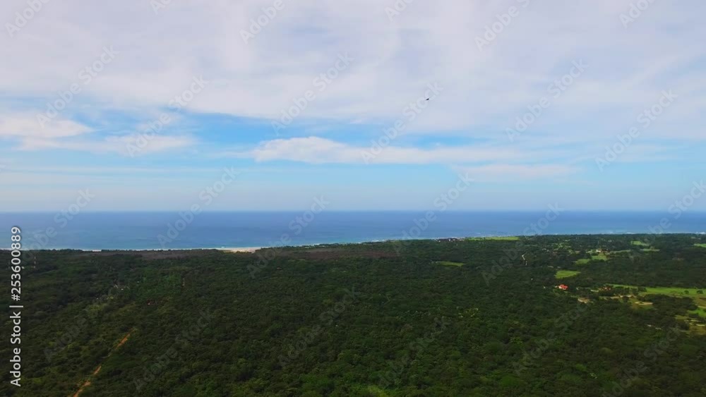 Aerial views over lush green horizon landscape watching hawk soaring across the sky with open wingspan. Aerial views over lush green horizon landscape watching hawk soaring across the sky with open wingspan.