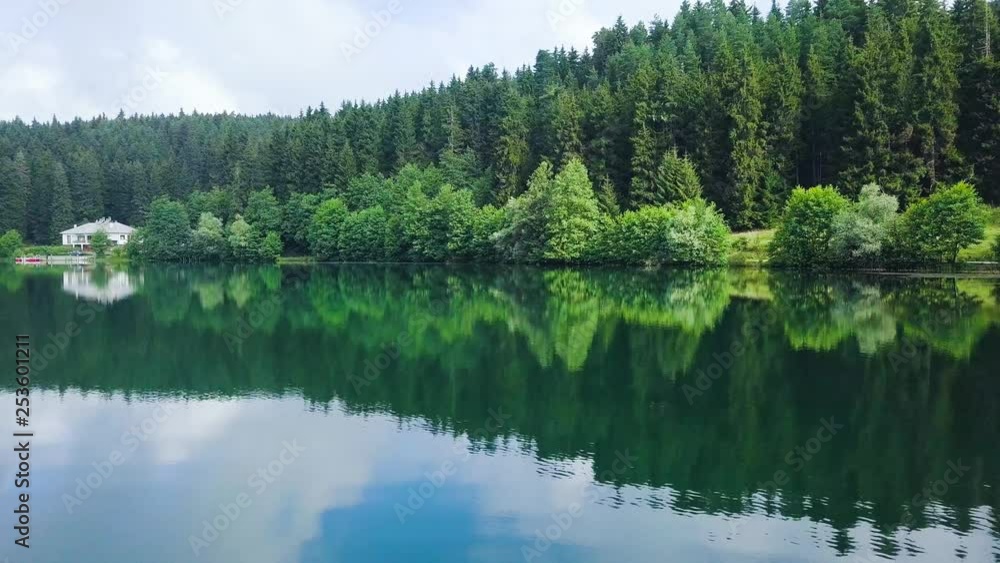 drone dolly sideways, close above the lake, a house in front of idyllic forest, lake reflecting pines anad clouds, in Karagol National Park, Savsat, Artvin, Turkey drone dolly sideways, close above the lake, a house in front of idyllic forest, lake reflecting pines anad clouds, in Karagol National Park, Savsat, Artvin, Turkey