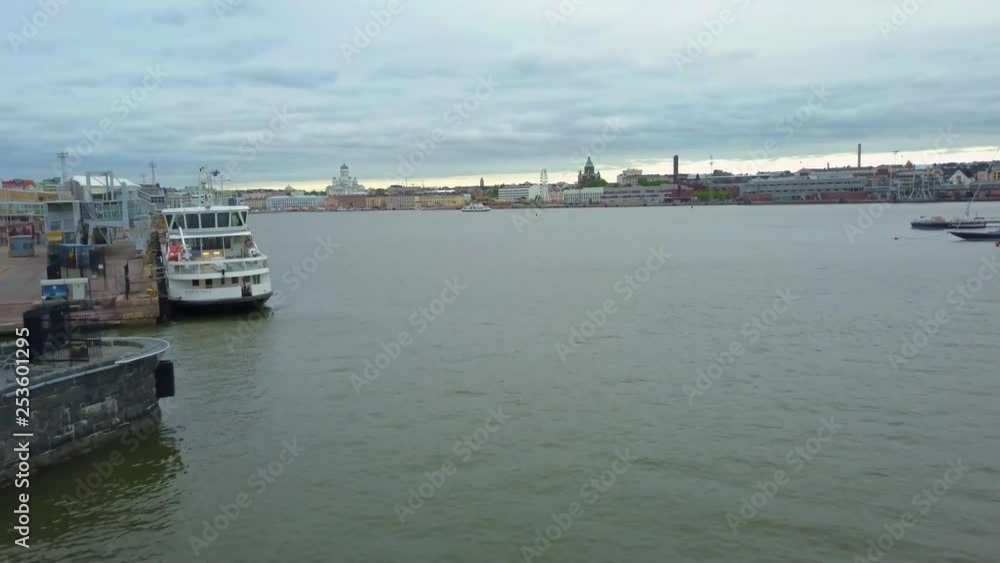 Aerial, drone shot, over the sea, towards the south harbor, the market square, the Skywheel and the cathedrals, on a half cloudy, summer morning, in Kruununhaka, Helsinki, Finland Aerial, drone shot, over the sea, towards the south harbor, the market square, the Skywheel and the cathedrals, on a half cloudy, summer morning, in Kruununhaka, Helsinki, Finland
