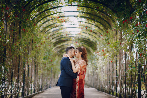 Photography Beautiful woman in a long red dress walks around the city with her husband in a
