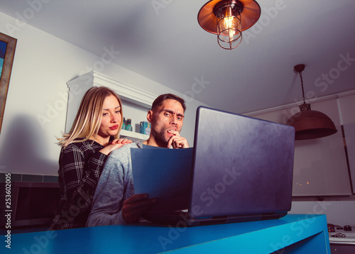 Concerned couple reading bad news in a letter at home.