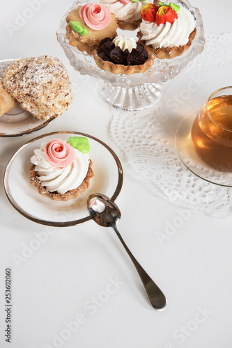 Cakes with tea on white bac...