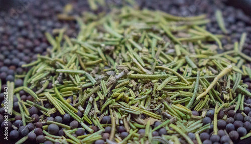 Dry rosemary with black mustard seeds closeup. Spices background. Organic healthy food. Cuisine and cooking concept. Herbs in the kitchen. Aroma herbs and spices. Black pepper seeds with rosemary. 