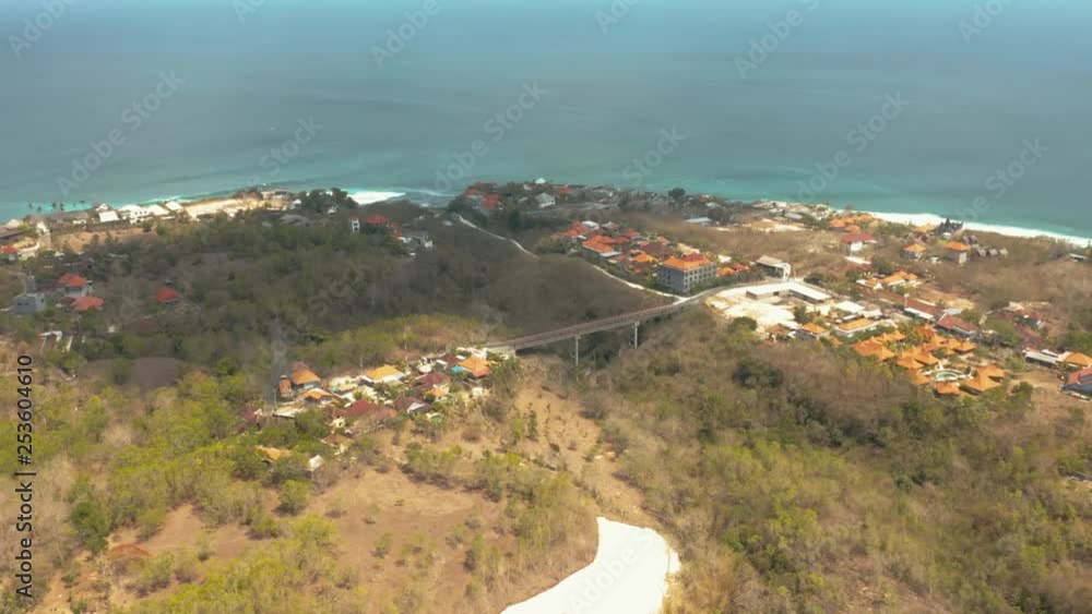 Drone shot pulling away over a coastal Indonesian town. The blue ocean in the distance. Drone shot pulling away over a coastal Indonesian town. The blue ocean in the distance.