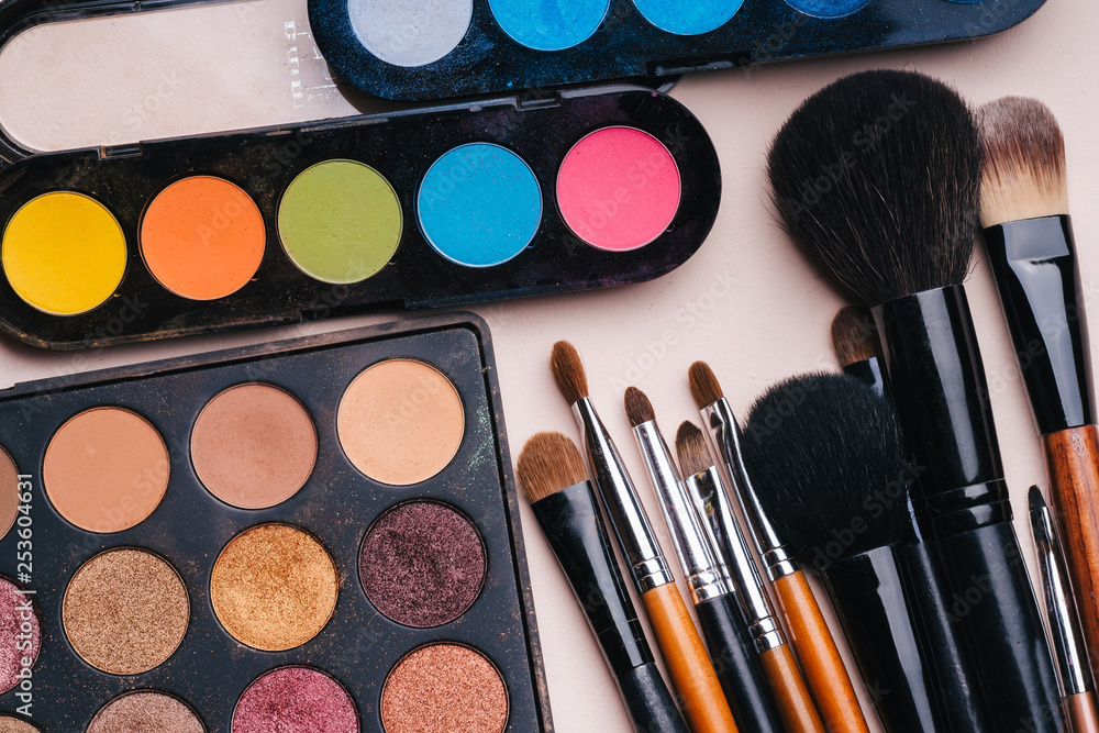 set of makeup brushes and palette with multi-colored eye shadows set of makeup brushes and palette with multi-colored eye shadows